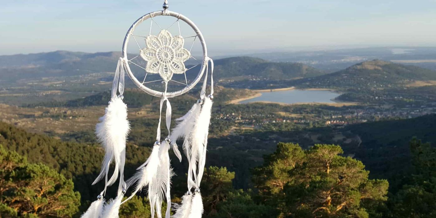 Atrapasueños blanco de crochet con lago al fondo